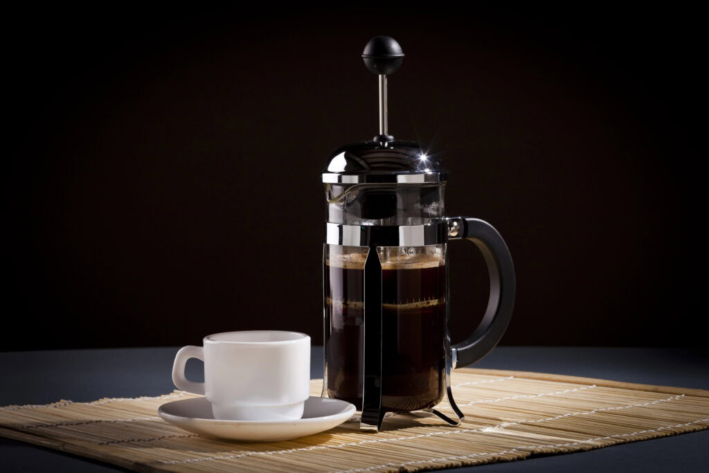 french press coffee maker and a cup of coffee | Hustle Coffee