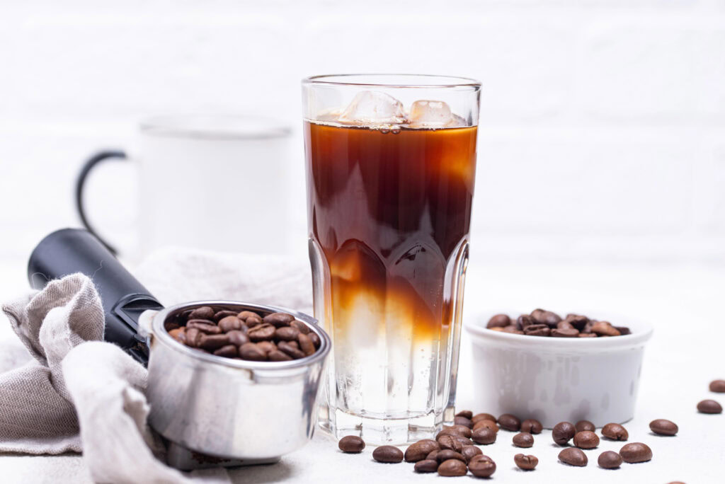 ice americano coffee in a glass and coffee beans | Hustle Coffee