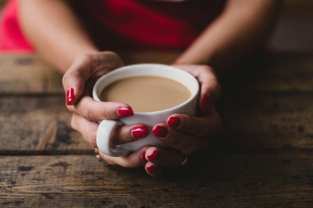 hand holding a cup of coffee | Hustle Coffee