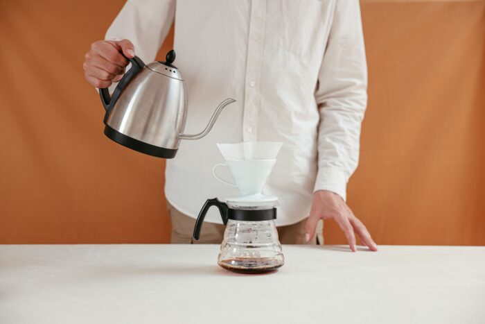 A person brewing pour-over coffee | Hustle Coffee